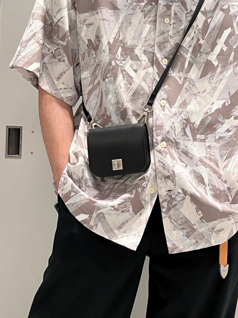 ベージュ系のシャツ/ブラウス、ブラック系のスラックス、ブラック系のドレスシューズを着用したメンズの春コーディネートの2枚目の写真