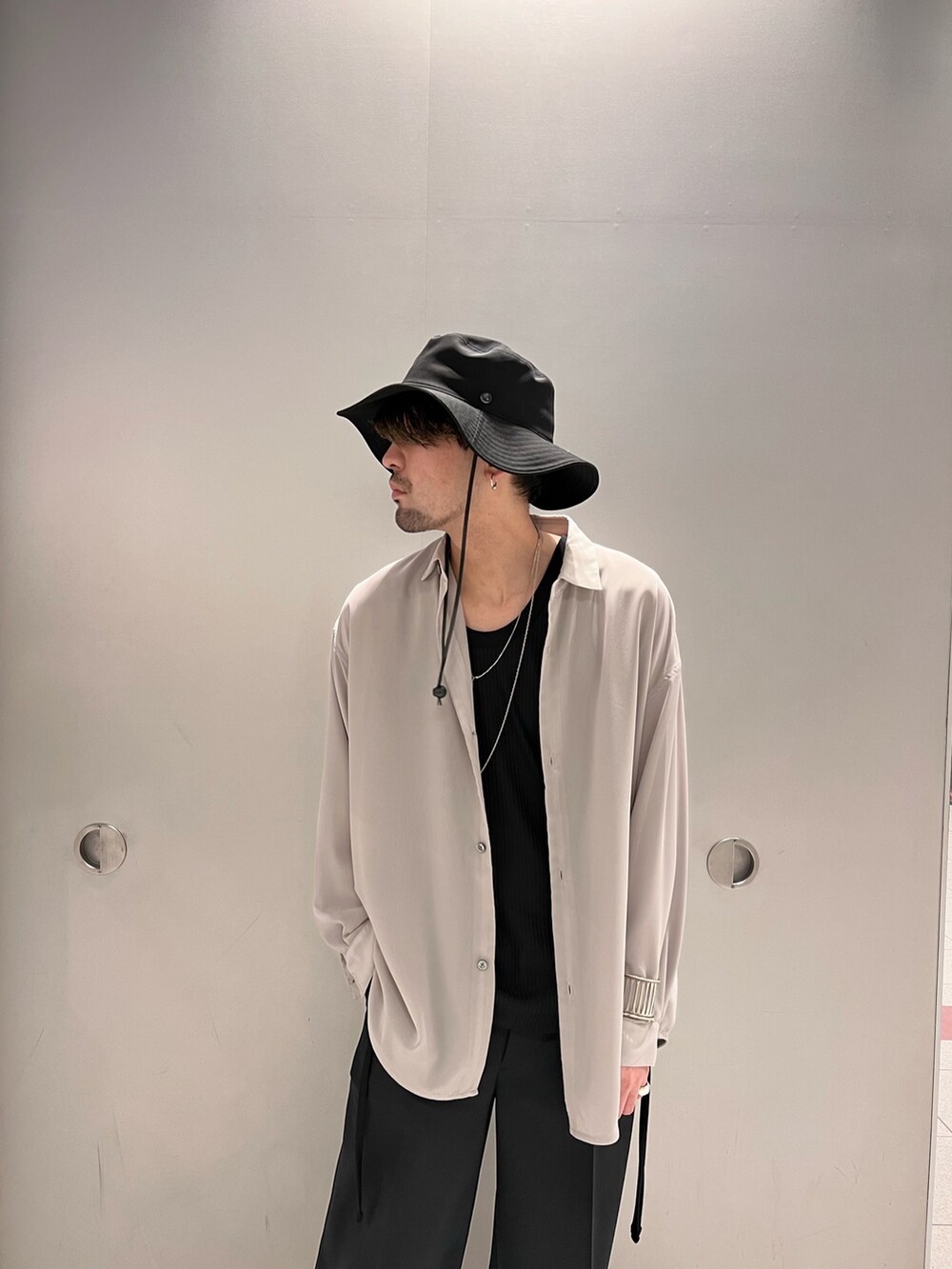 グレー系のシャツ/ブラウス、ブラック系のトップス、ブラック系のスラックスを着用したメンズの春コーディネートの4枚目の写真