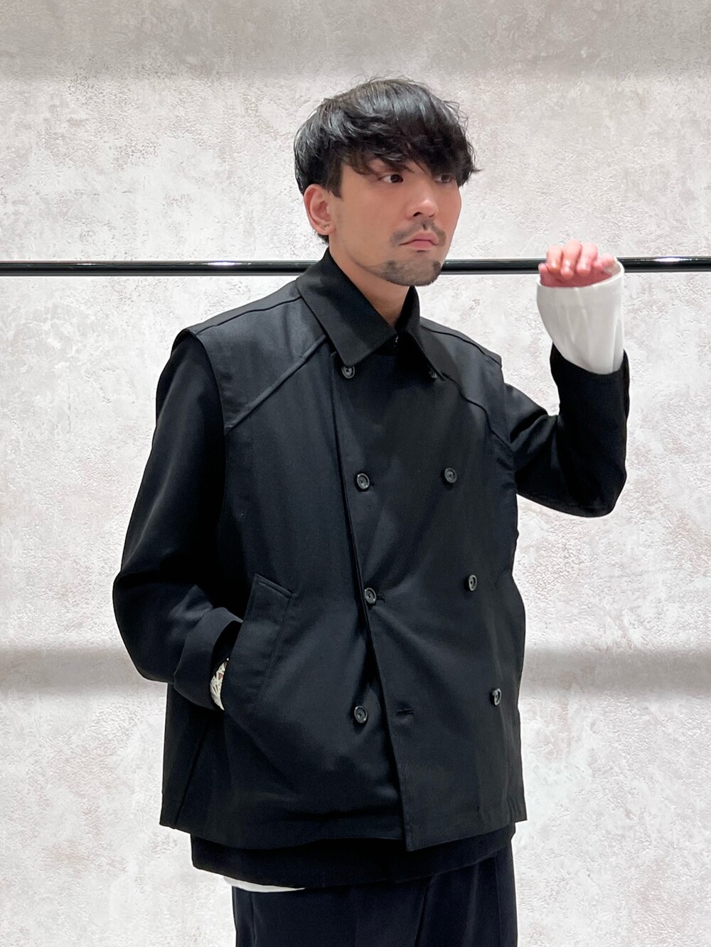 ブラック系のベスト、ブルー系のショルダーバッグ、ブラック系のテーラードジャケットを着用したメンズの秋コーディネートの2枚目の写真