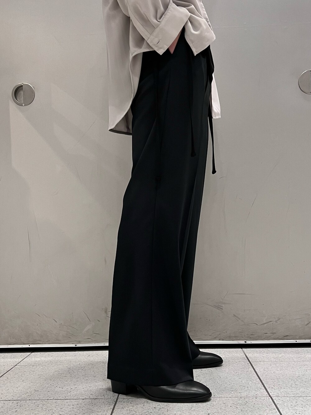 グレー系のシャツ/ブラウス、ブラック系のトップス、ブラック系のスラックスを着用したメンズの春コーディネートの5枚目の写真