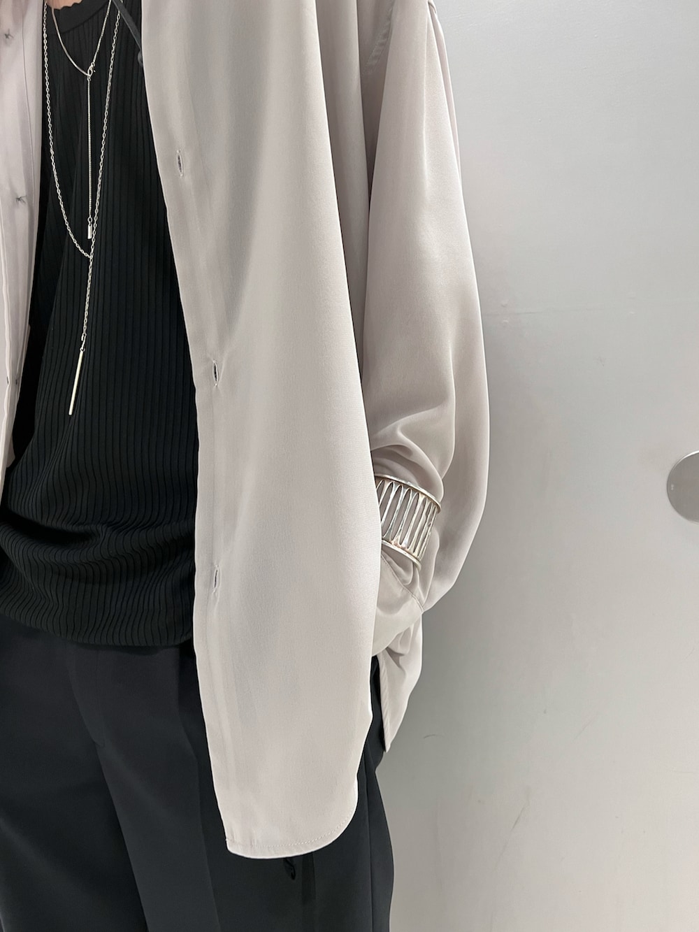 グレー系のシャツ/ブラウス、ブラック系のトップス、ブラック系のスラックスを着用したメンズの春コーディネートの3枚目の写真