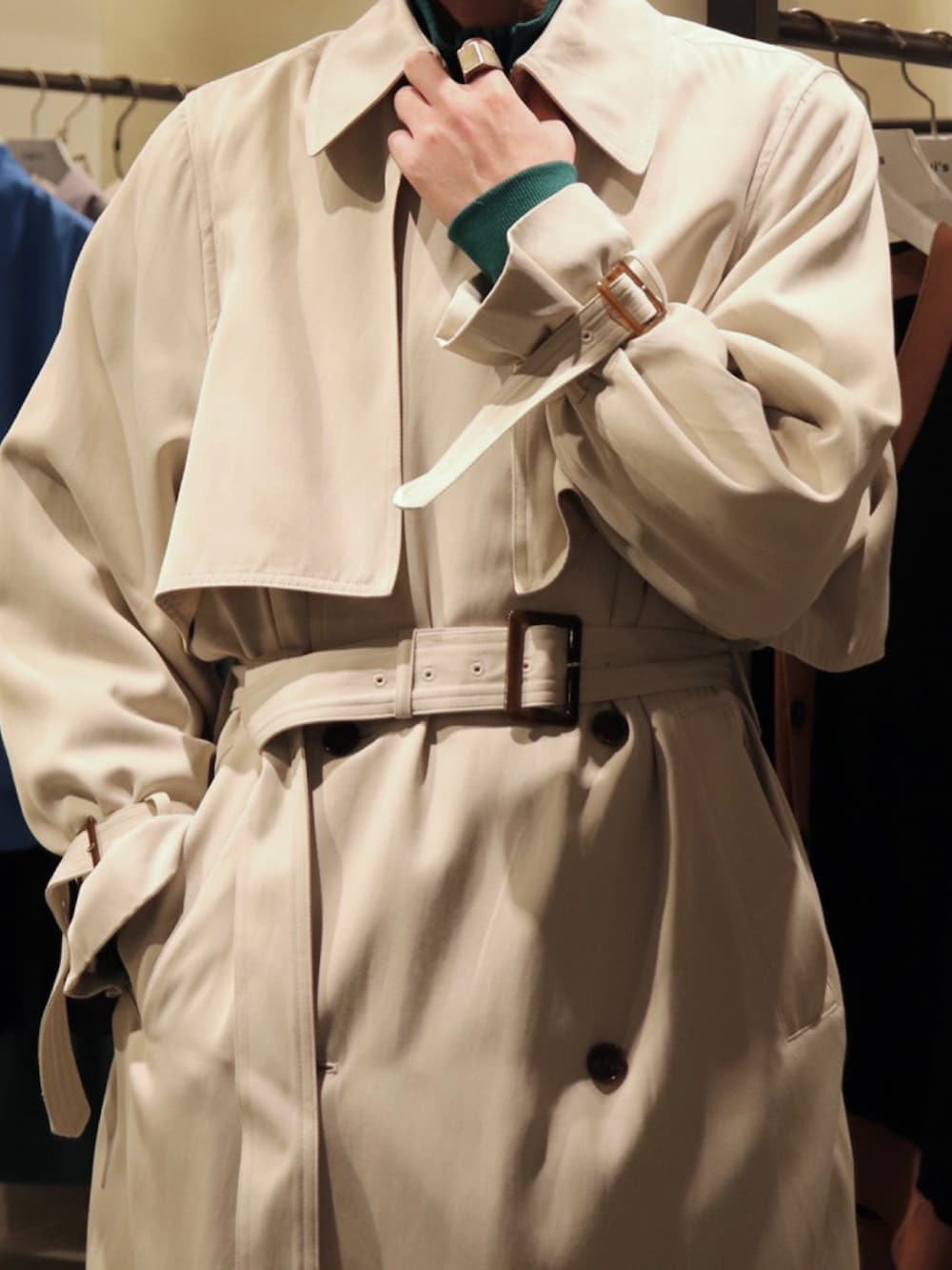 ベージュ系のトレンチコート、ブラック系のスラックス、グリーン系のブルゾンを着用したメンズの冬コーディネートの4枚目の写真