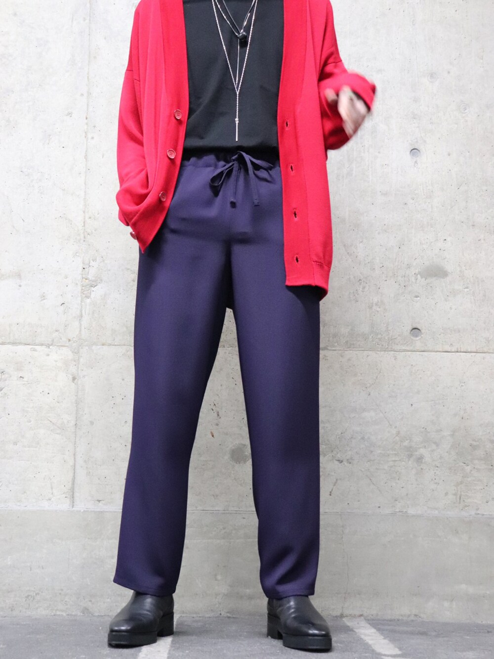 ブラック系のテーラードジャケット、レッド系のカーディガン/ボレロ、パープル系のパンツを着用したメンズの冬コーディネートの3枚目の写真