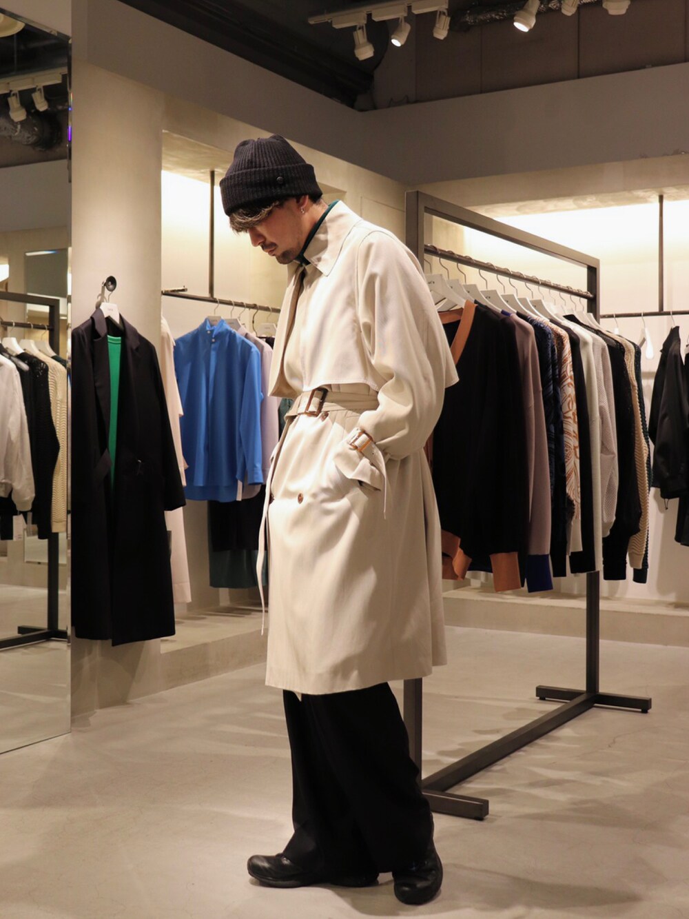 ベージュ系のトレンチコート、ブラック系のスラックス、グリーン系のブルゾンを着用したメンズの冬コーディネートの3枚目の写真