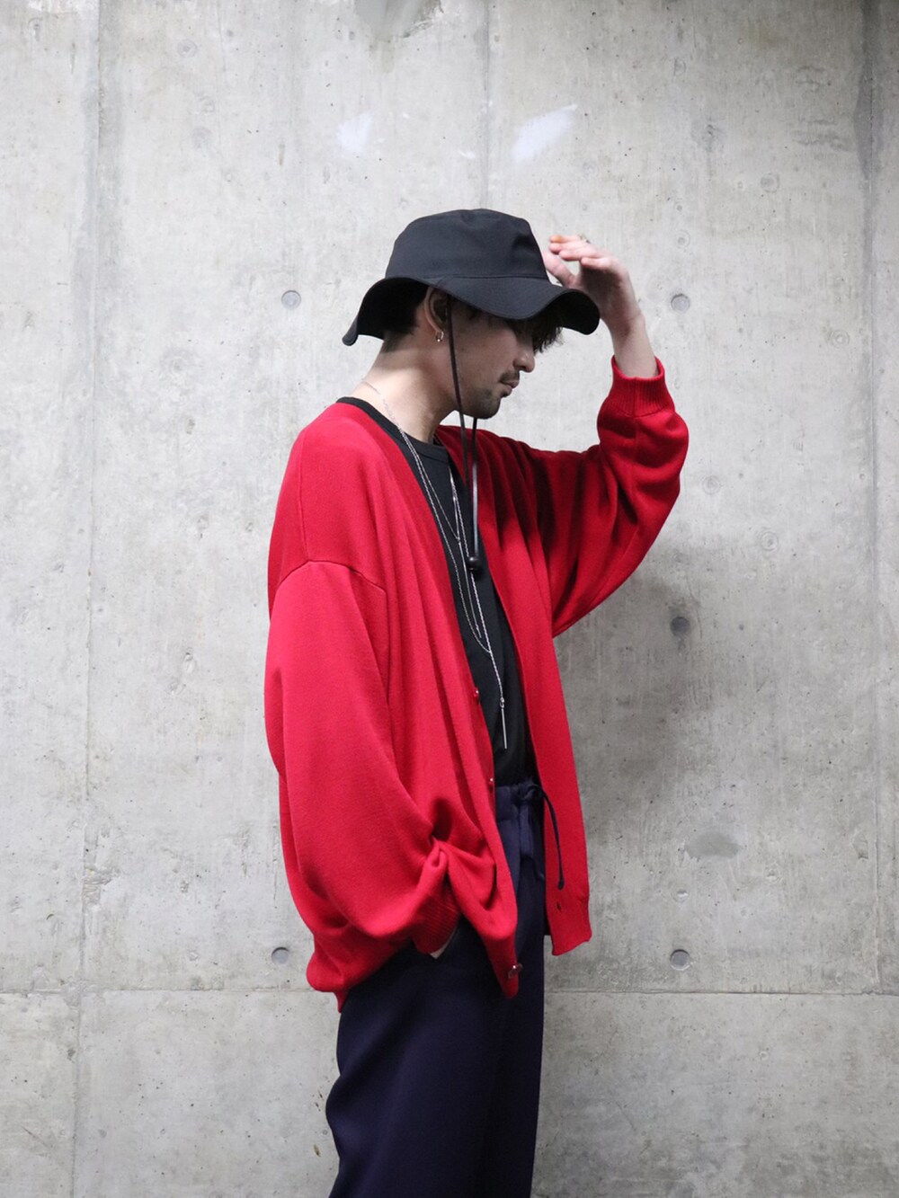 ブラック系のテーラードジャケット、レッド系のカーディガン/ボレロ、パープル系のパンツを着用したメンズの冬コーディネートの2枚目の写真