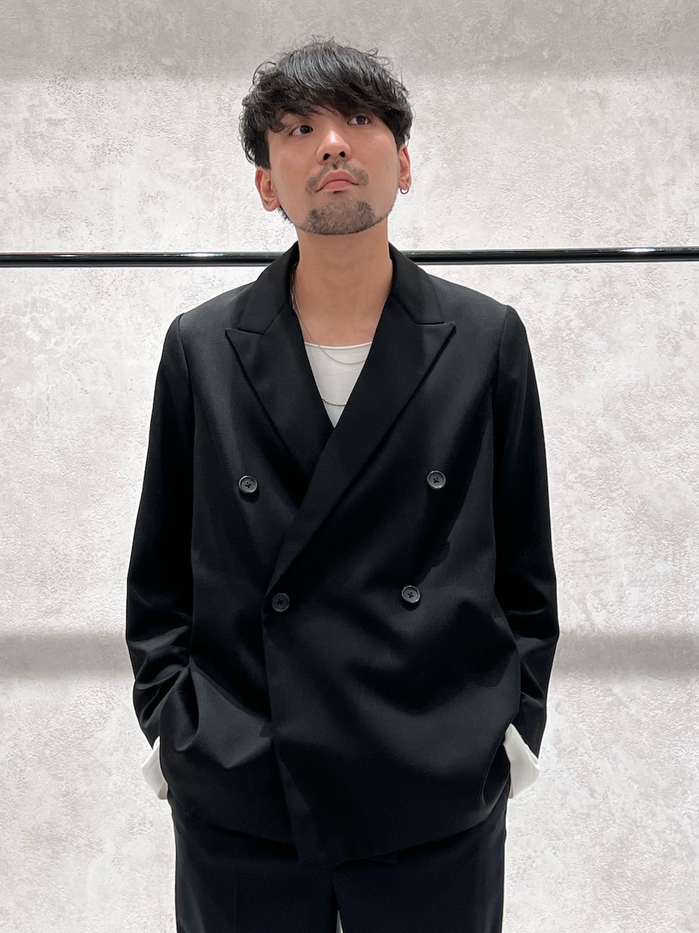 ブラック系のベスト、ブルー系のショルダーバッグ、ブラック系のテーラードジャケットを着用したメンズの秋コーディネートの3枚目の写真