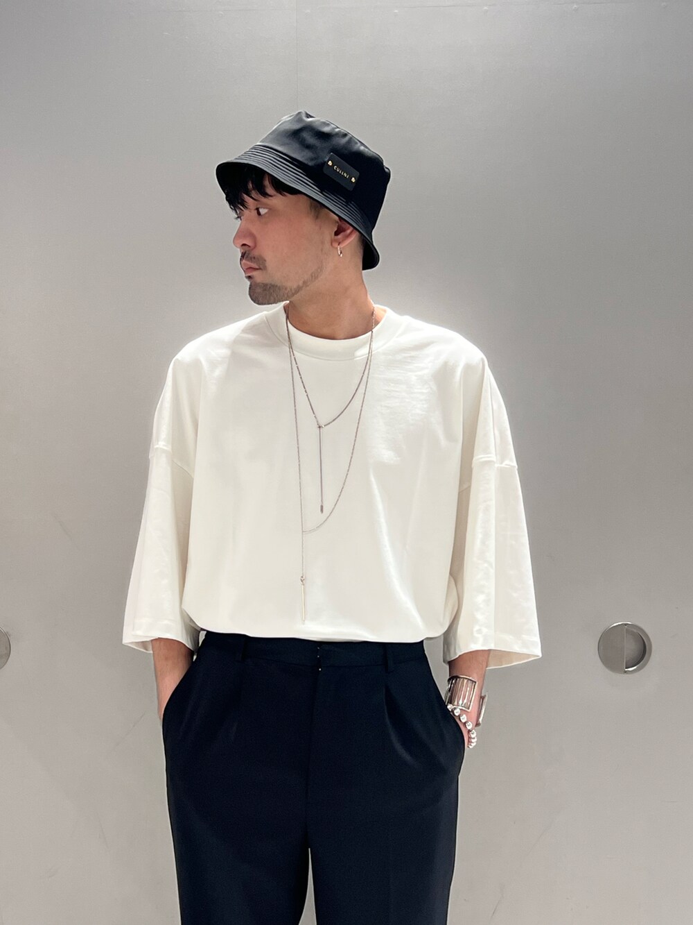 グレー系のベスト、ホワイト系のTシャツ/カットソー、ブラック系のトートバッグを着用したメンズの春コーディネートの5枚目の写真