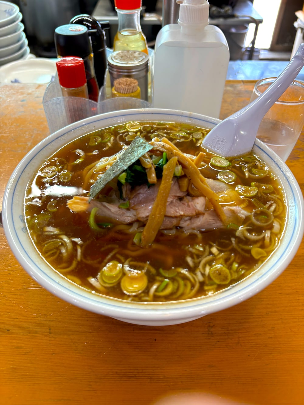 レッド系のシャツ/ブラウス、ブルー系のチェスターコート、グリーン系のチノパンツを着用したメンズの春コーディネートの2枚目の写真