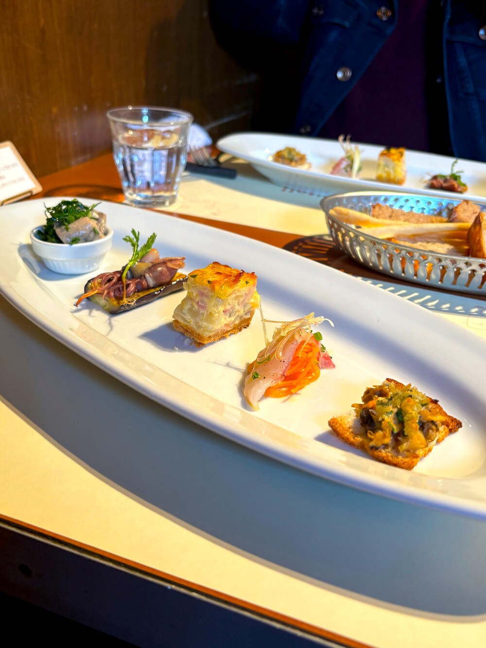 ブルー系のデニムパンツ、グリーン系のスニーカー、ベージュ系のその他トップスを着用したメンズの春コーディネートの2枚目の写真