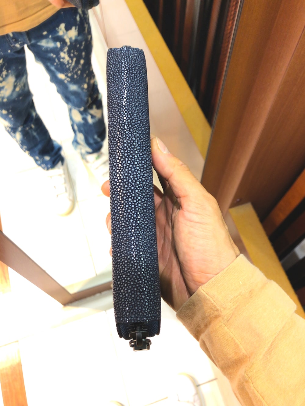 ブルー系のデニムパンツ、グリーン系のスニーカー、ブラック系のマウンテンパーカーを着用したメンズの冬コーディネートの4枚目の写真