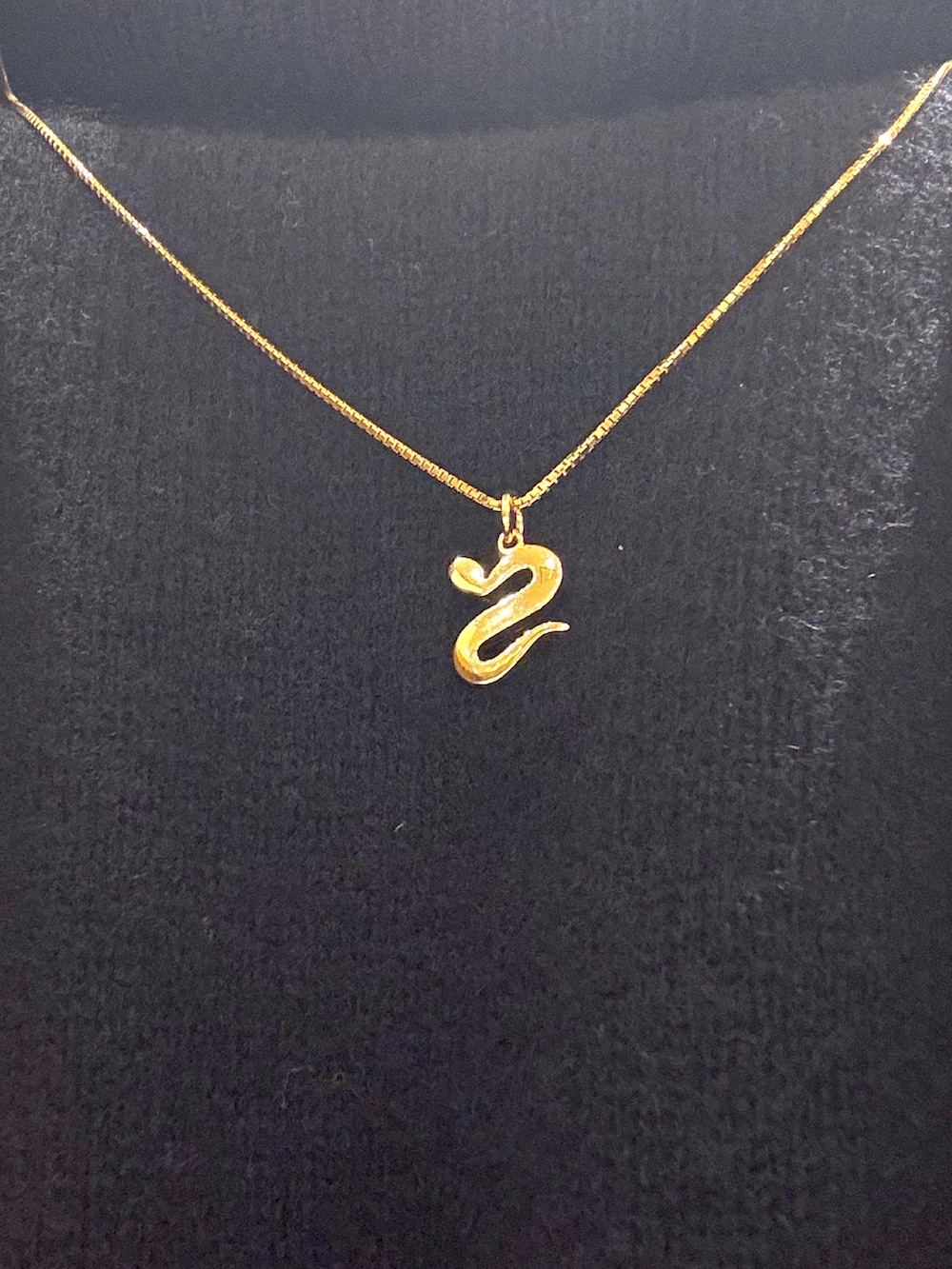 ブラック系のニット/セーター、ベージュ系のチェスターコート、ブルー系のデニムパンツを着用したメンズの冬コーディネートの2枚目の写真