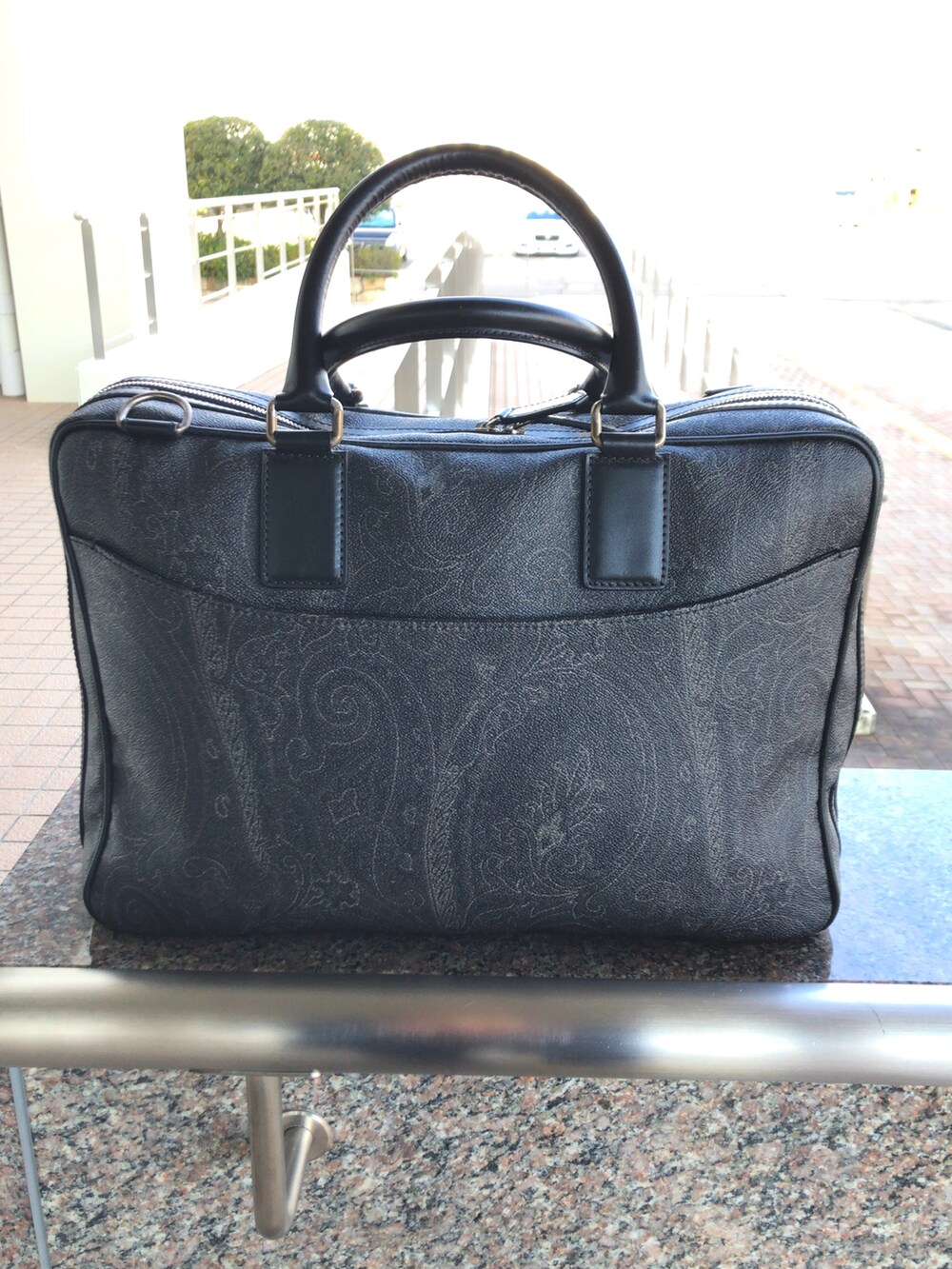 ブラウン系のブーツ、ブラック系のビジネスバッグ、ブルー系のチェスターコートを着用したメンズの冬コーディネートの3枚目の写真