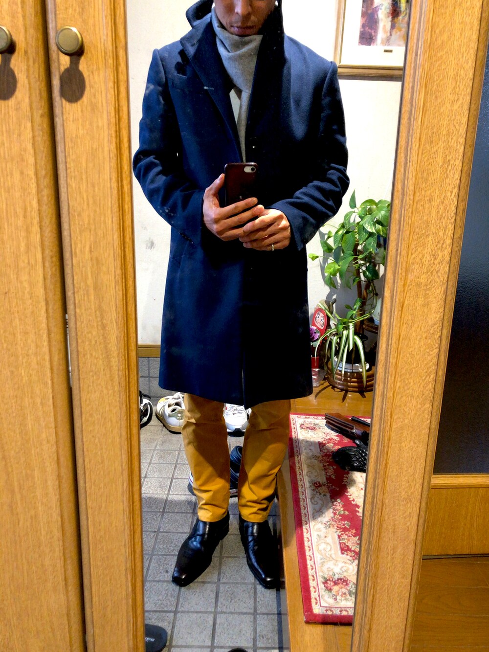 その他のチノパンツ、ブラック系のローファー、ブルー系のチェスターコートを着用したメンズの冬コーディネートの2枚目の写真