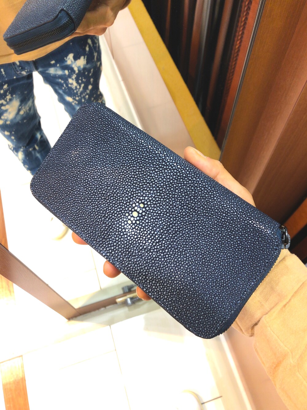 ブルー系のデニムパンツ、グリーン系のスニーカー、ブラック系のマウンテンパーカーを着用したメンズの冬コーディネートの2枚目の写真