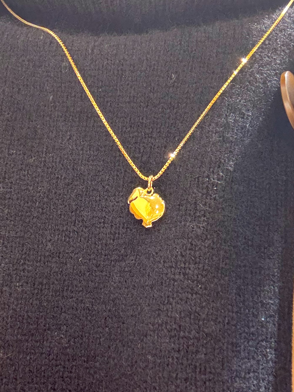 ブラック系のニット/セーター、ベージュ系のチェスターコート、ブルー系のデニムパンツを着用したメンズの冬コーディネートの3枚目の写真