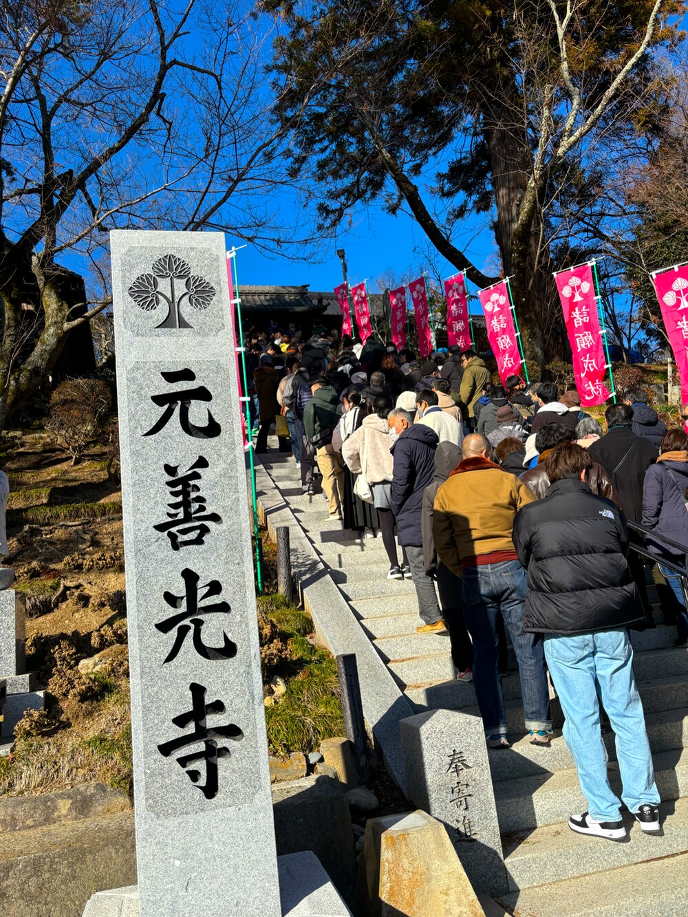 ベージュ系のその他パンツ、レッド系のスリッポン、ブルー系のマウンテンパーカーを着用したメンズの冬コーディネートの3枚目の写真