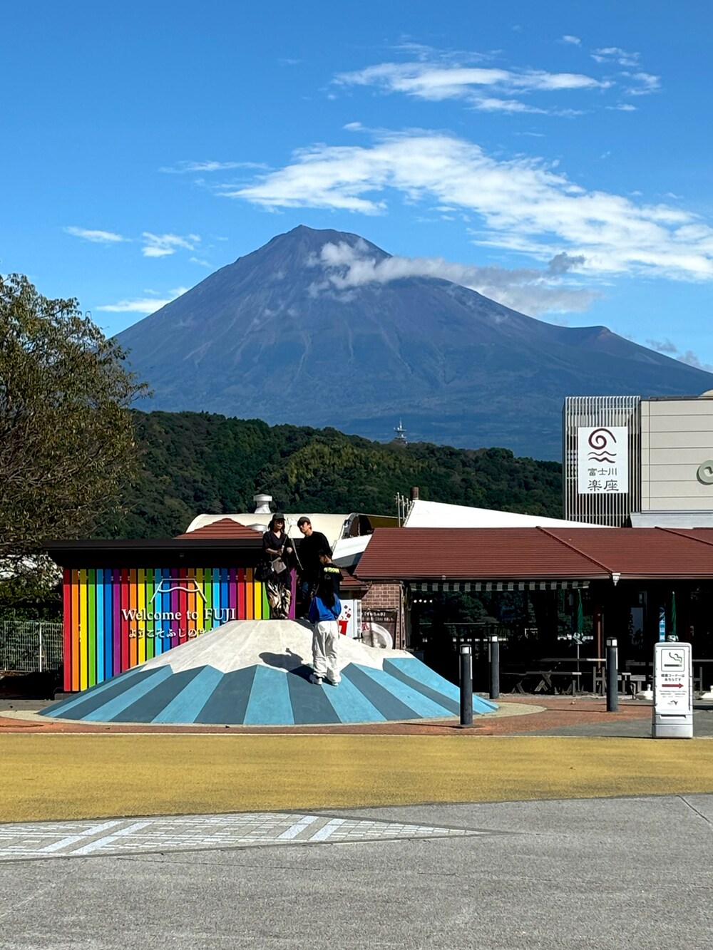 グリーン系のチノパンツ、ブルー系のトートバッグ、グリーン系のスニーカーを着用したメンズの秋コーディネートの5枚目の写真