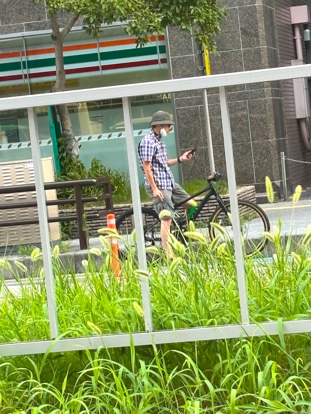 ブルー系のデニムパンツ、ブラック系のサンダル、ホワイト系のTシャツ/カットソーを着用したメンズの夏コーディネートの2枚目の写真