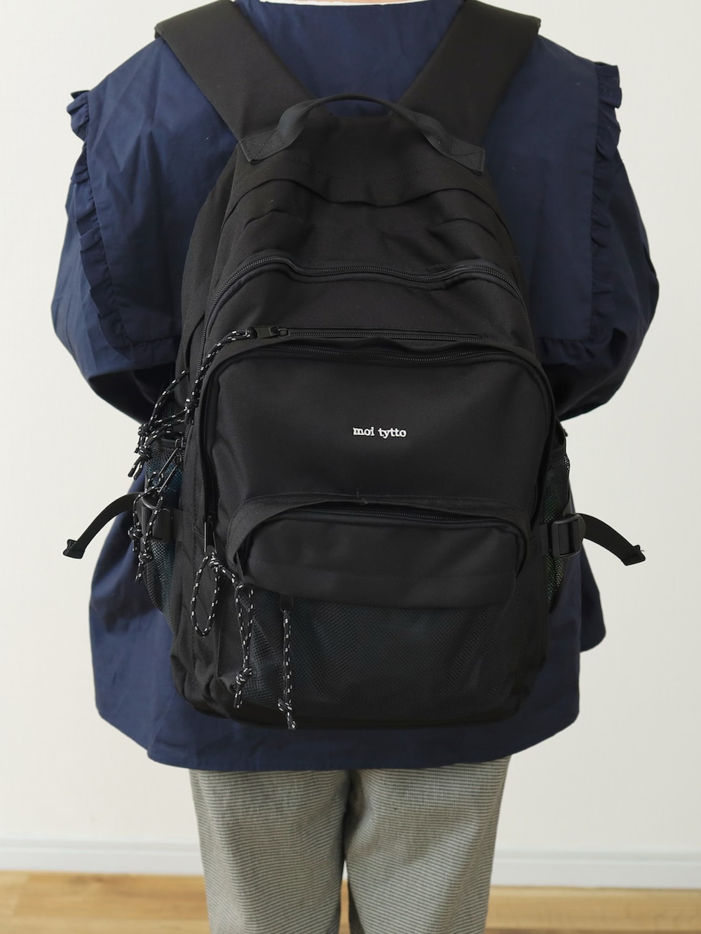 ブラック系のその他パンツ、ブラック系のバックパック/リュック、ブルー系のシューズを着用したレディースの春コーディネートの5枚目の写真