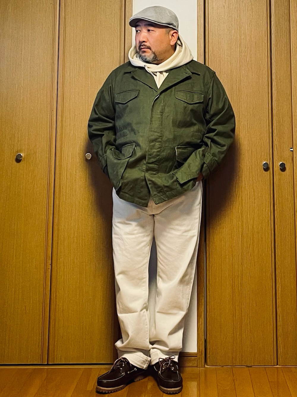 ブラウン系のモカシン/デッキシューズ、ホワイト系のデニムパンツ、ホワイト系のパーカーを着用したメンズの春コーディネートの2枚目の写真