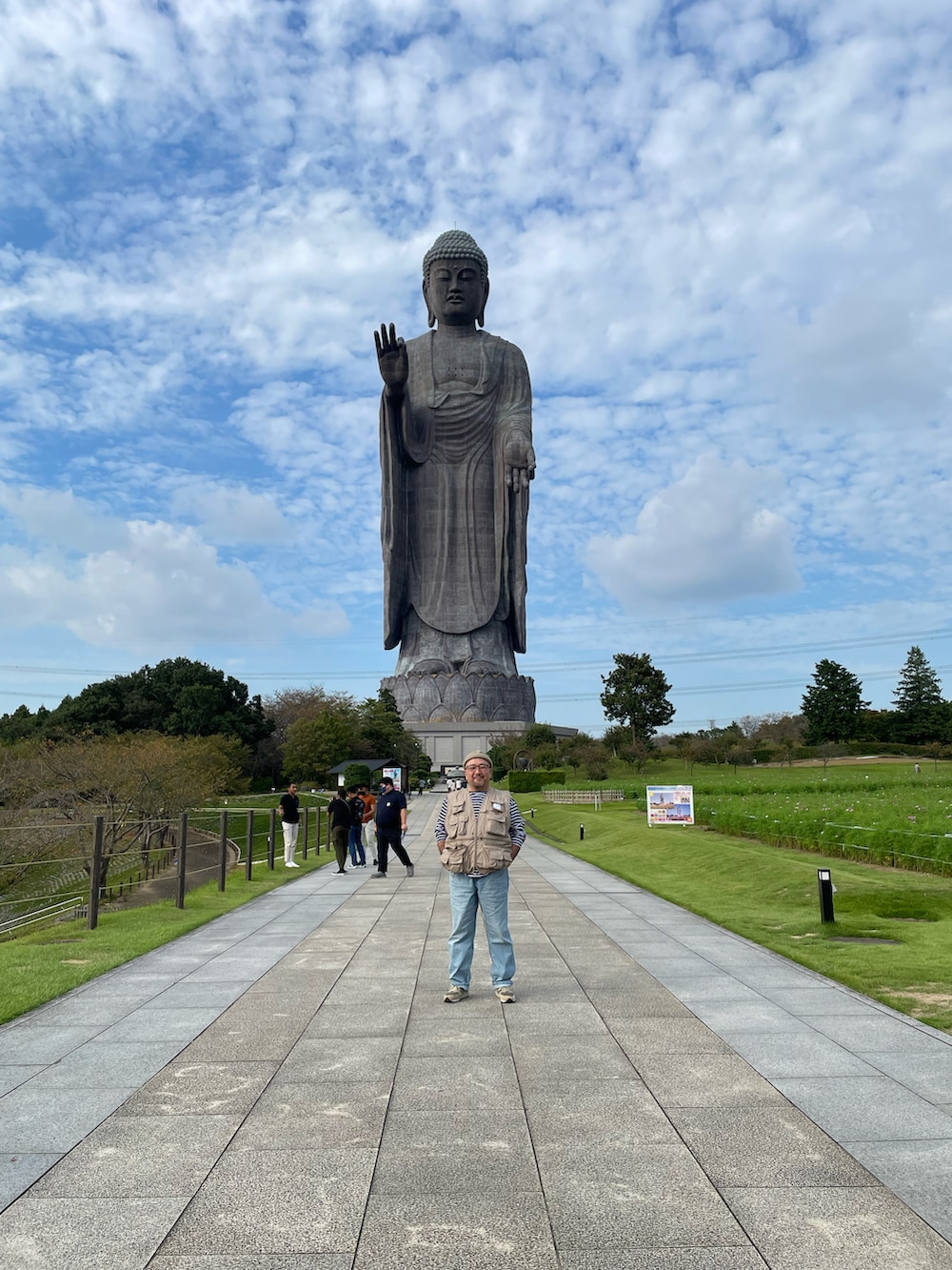 ブルー系のデニムパンツ、ベージュ系のベスト、ブルー系のTシャツ/カットソーを着用したメンズの秋コーディネートの2枚目の写真