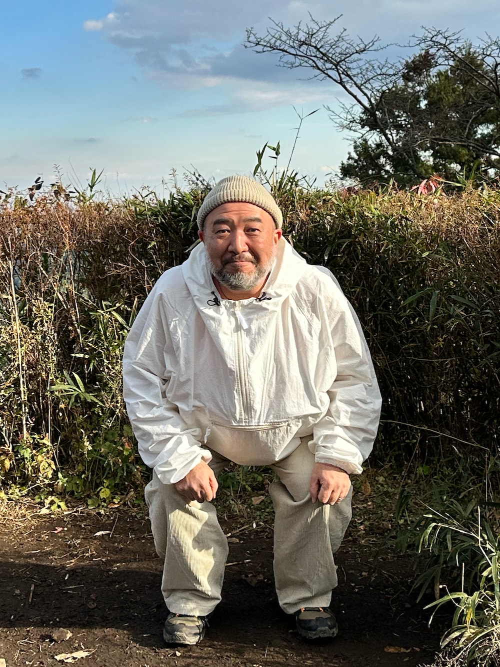 ベージュ系のパンツ、ホワイト系のマウンテンパーカーを着用したメンズの冬コーディネートの2枚目の写真