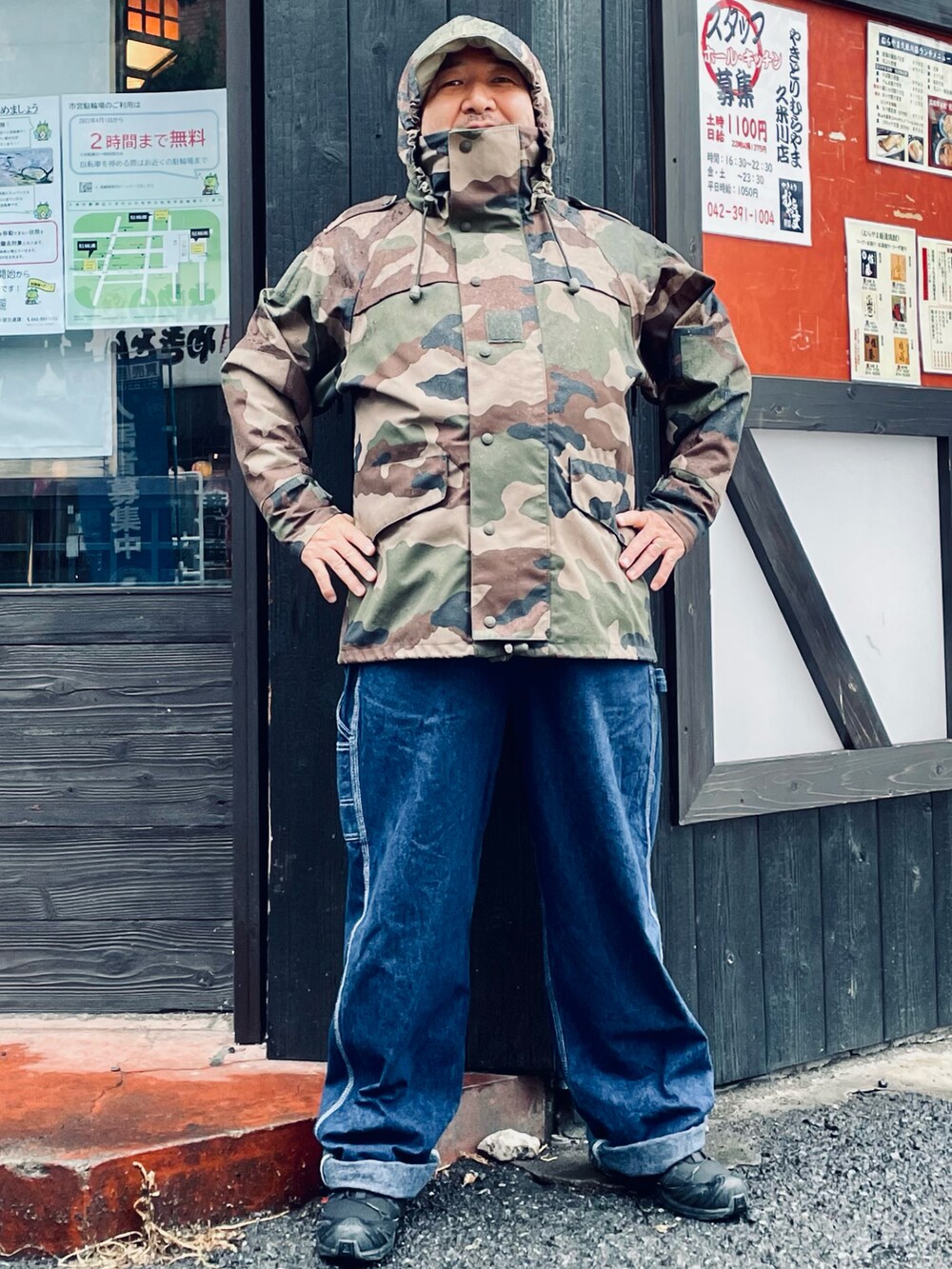 グリーン系のミリタリージャケット、ブルー系のサロペット/オーバーオール、ホワイト系のTシャツ/カットソーを着用したメンズの春コーディネートの2枚目の写真