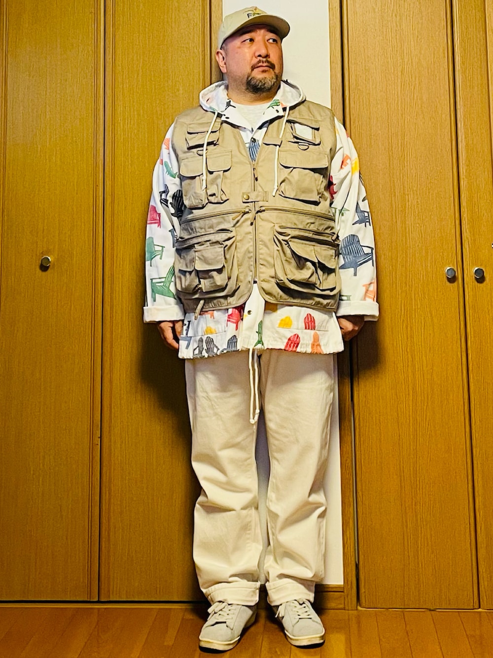 グレー系のスウェット、ベージュ系のベスト、ホワイト系のデニムパンツを着用したメンズの春コーディネートの2枚目の写真