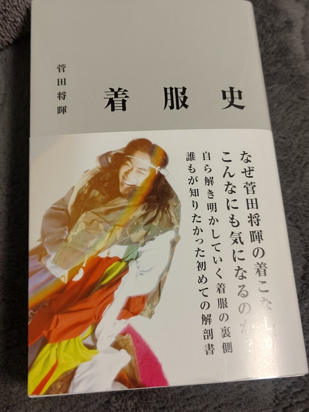 ブラウン系のトレンチコート、レッド系のスラックス、ブラック系のスニーカーを着用したメンズの春コーディネートの3枚目の写真