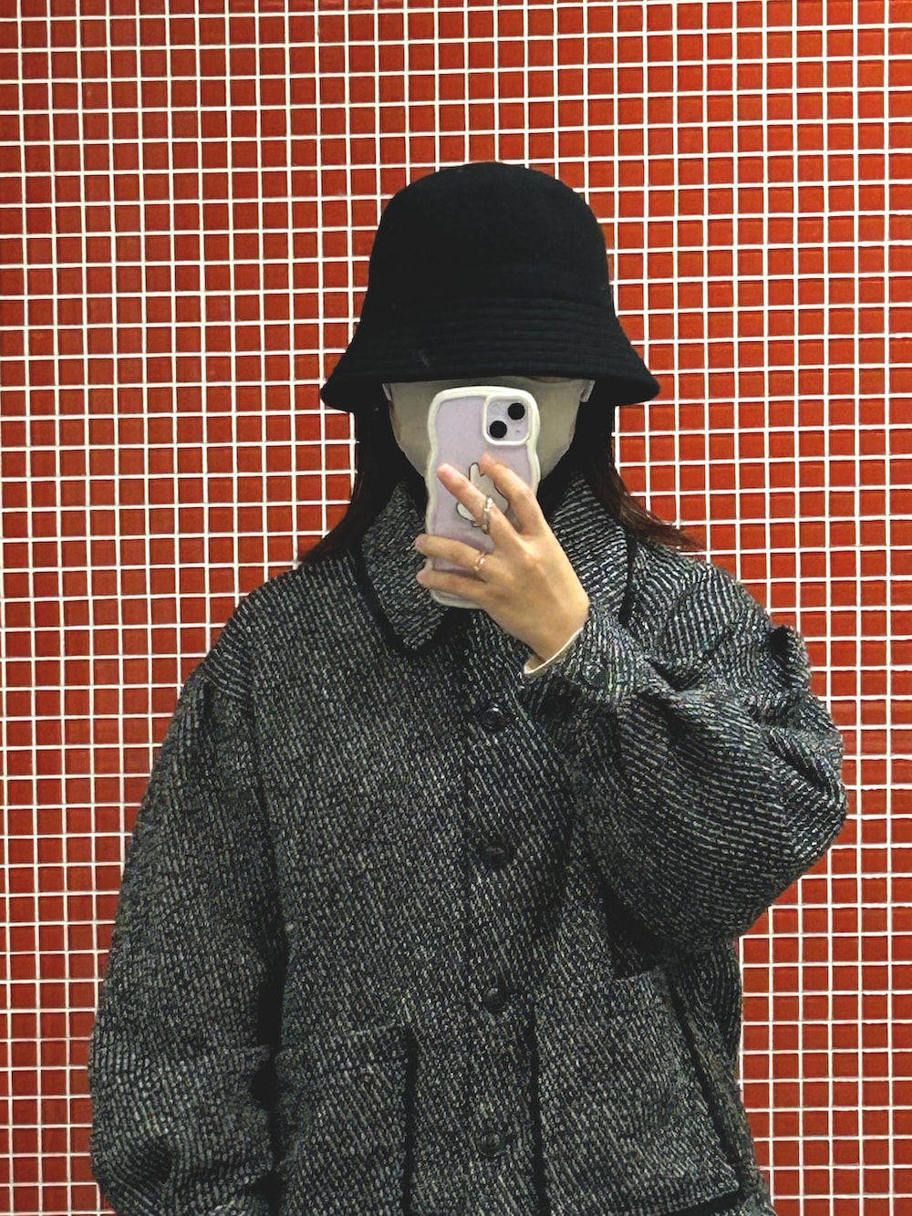 ブラック系のテーラードジャケット、ベージュ系のショルダーバッグ、ブラック系のハットを着用したレディースの冬コーディネートの2枚目の写真