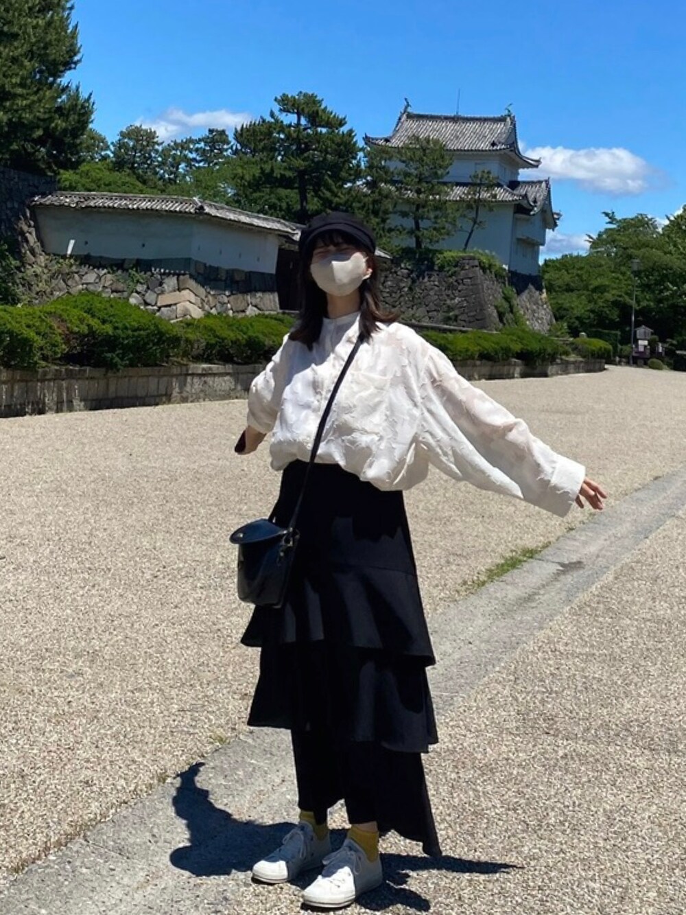 ホワイト系のシャツ/ブラウス、ブラック系のスカート、ホワイト系のスニーカーを着用したレディースの秋コーディネートの2枚目の写真