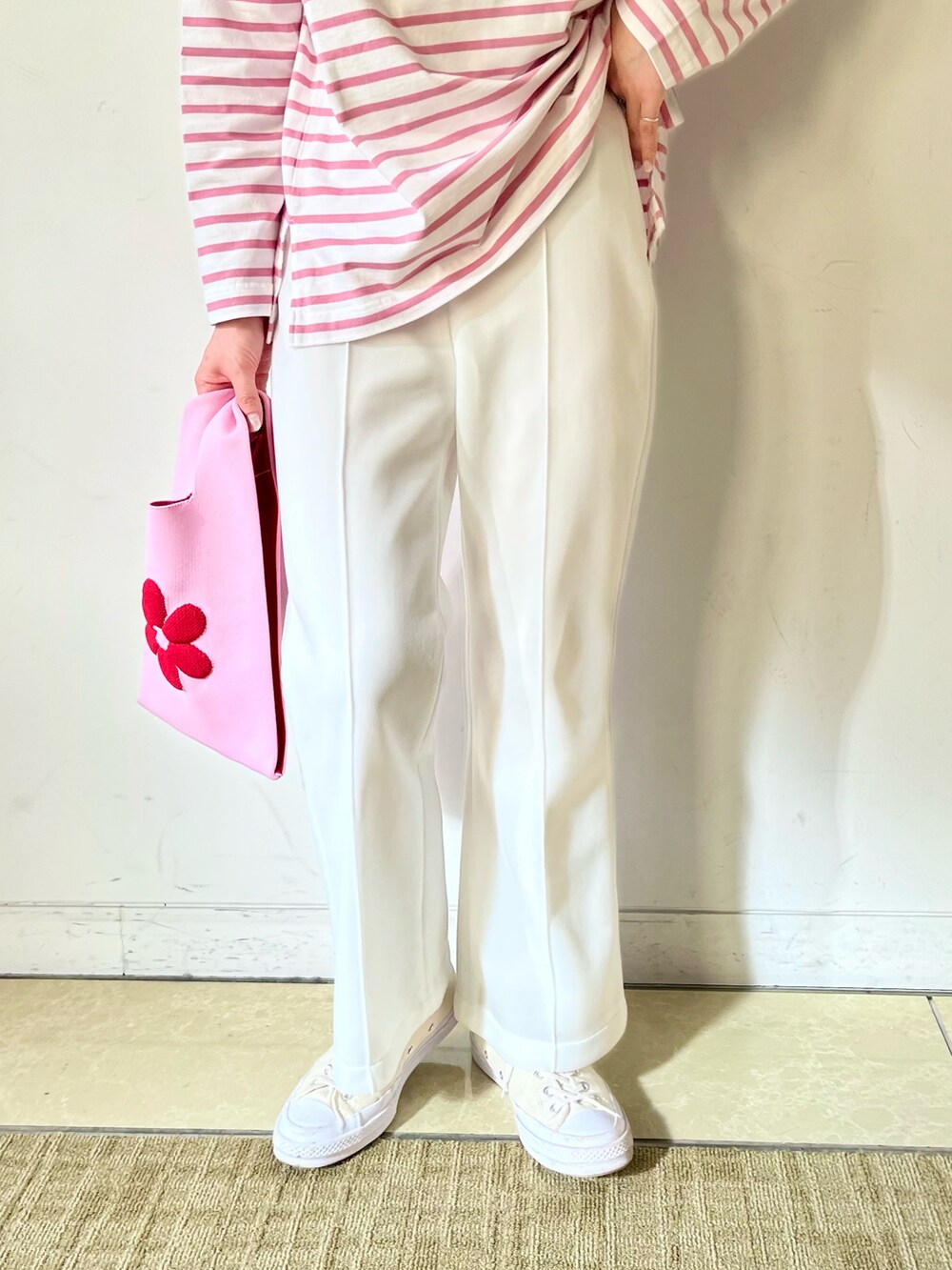 ピンク系のトートバッグ、ピンク系のTシャツ/カットソー、ホワイト系のその他パンツを着用したレディースの冬コーディネートの3枚目の写真