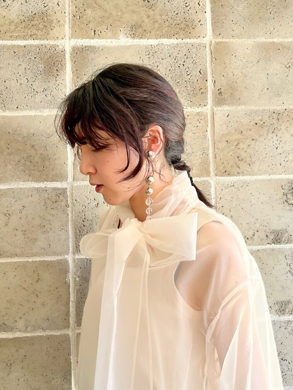 ブラック系のスカート、ブラウン系のブーツ、ホワイト系のタンクトップを着用したレディースの春コーディネートの4枚目の写真