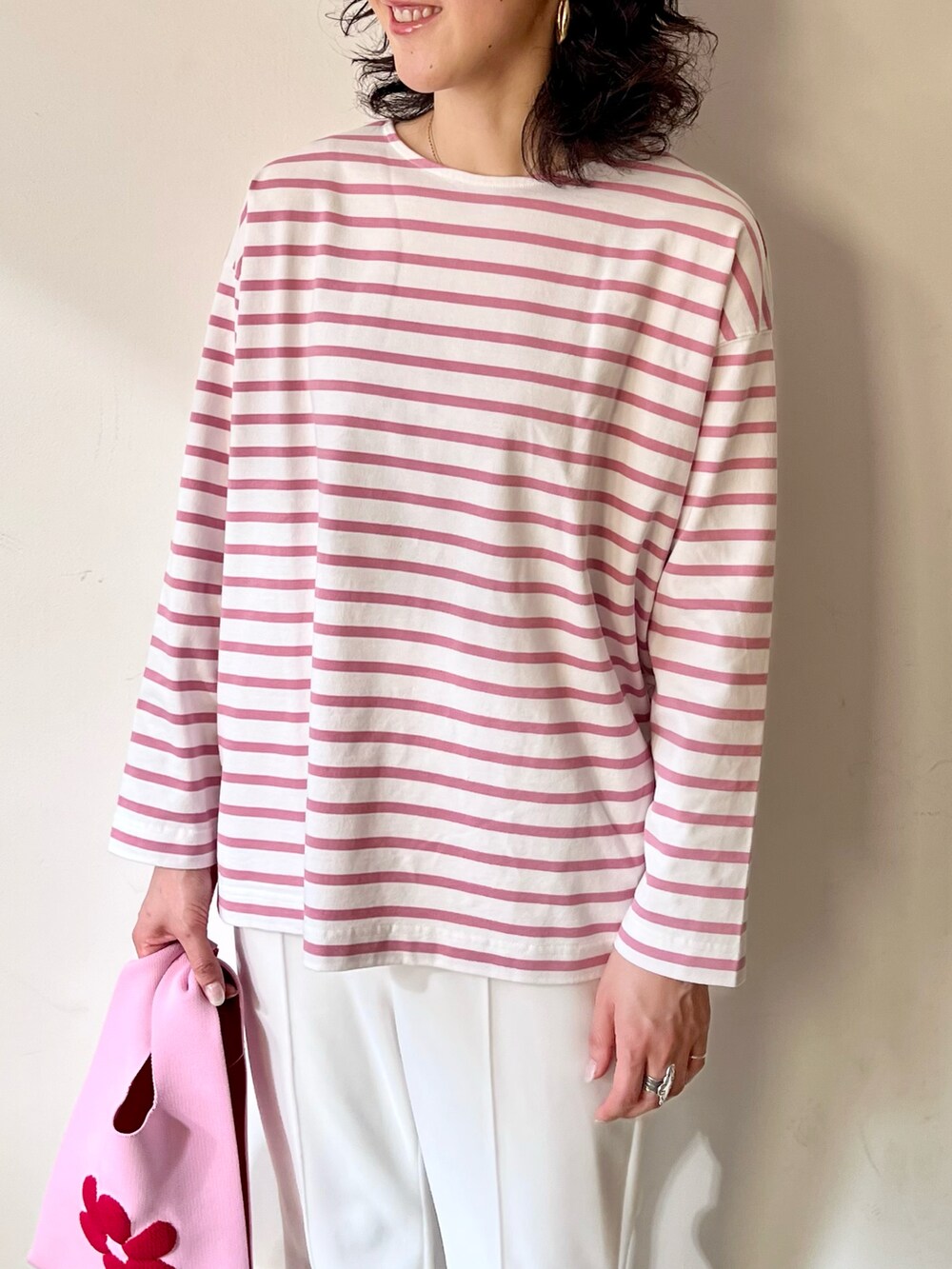 ピンク系のトートバッグ、ピンク系のTシャツ/カットソー、ホワイト系のその他パンツを着用したレディースの冬コーディネートの4枚目の写真