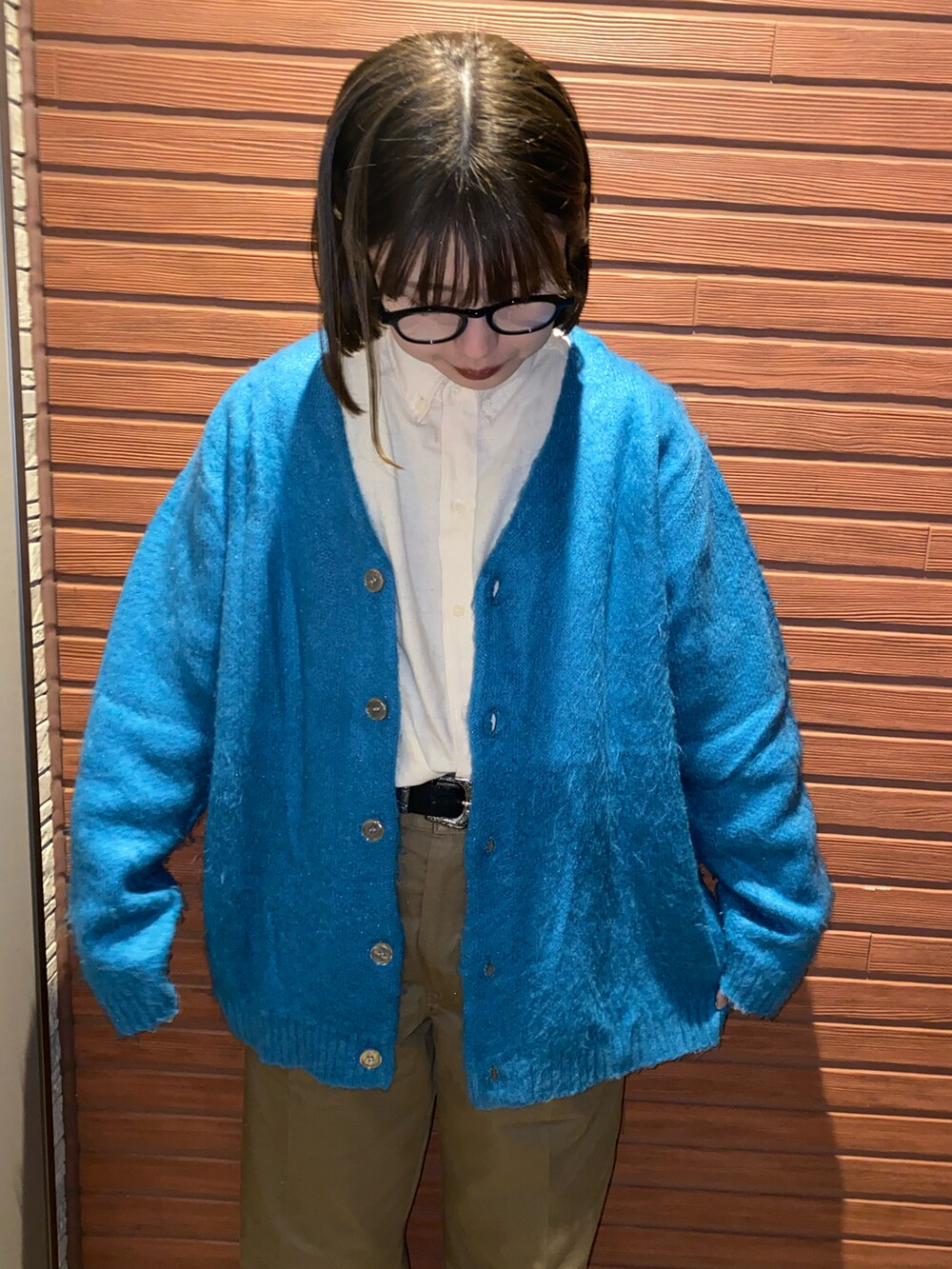 ベージュ系のシャツ/ブラウス、ブルー系のカーディガン/ボレロ、ブラウン系のチノパンツを着用したレディースの秋コーディネートの2枚目の写真