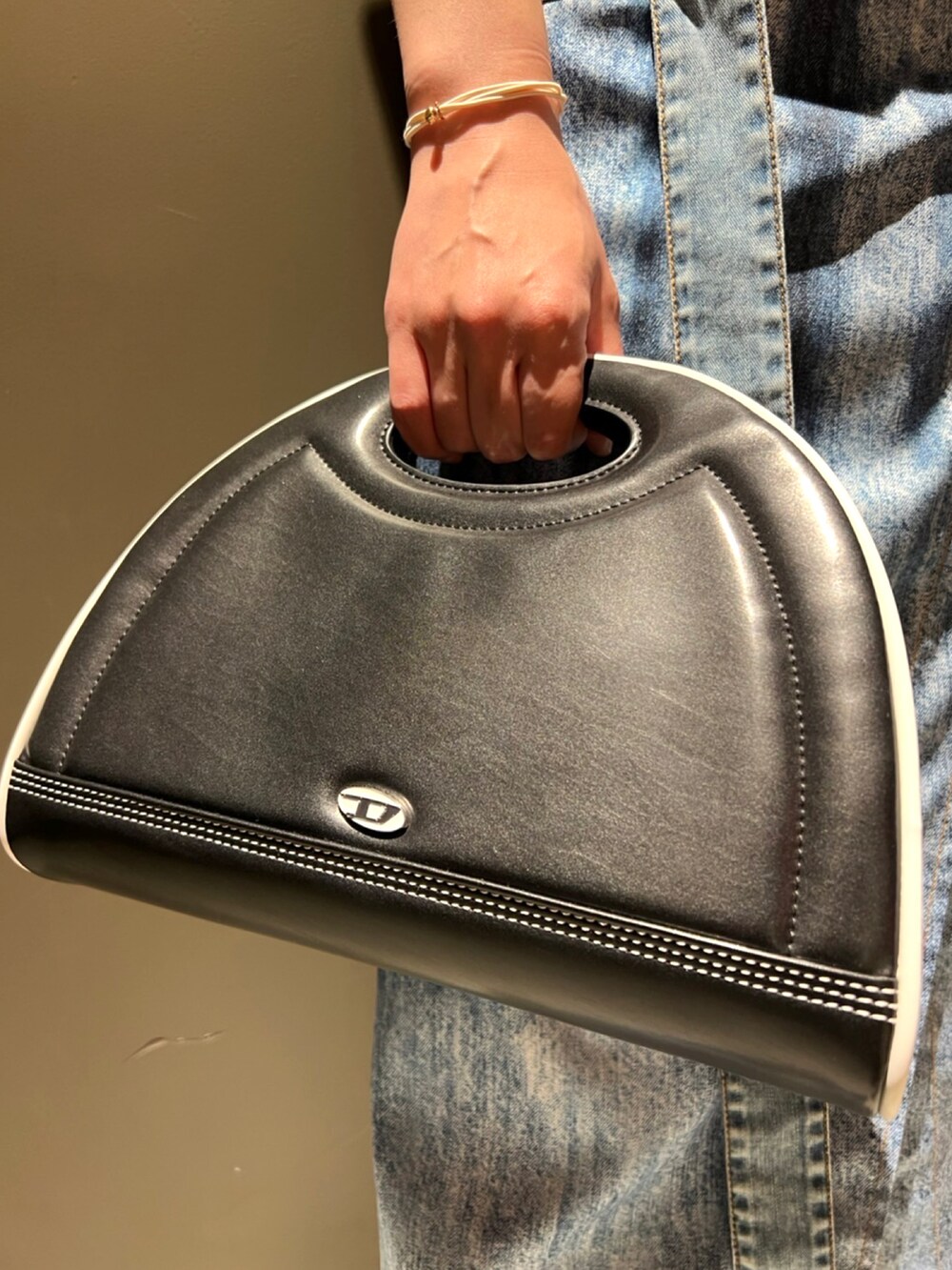 ブラック系のワンピース、ブラック系のハンドバッグ、ブルー系のスカートを着用したレディースの夏コーディネートの2枚目の写真