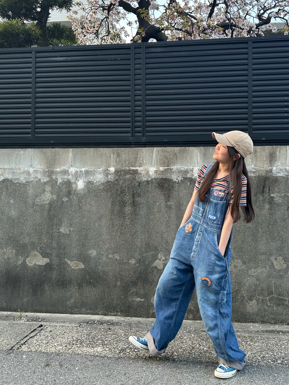 ブルー系のオールインワン・サロペット、グリーン系のスニーカー、ベージュ系のキャップを着用したキッズの春コーディネートの4枚目の写真