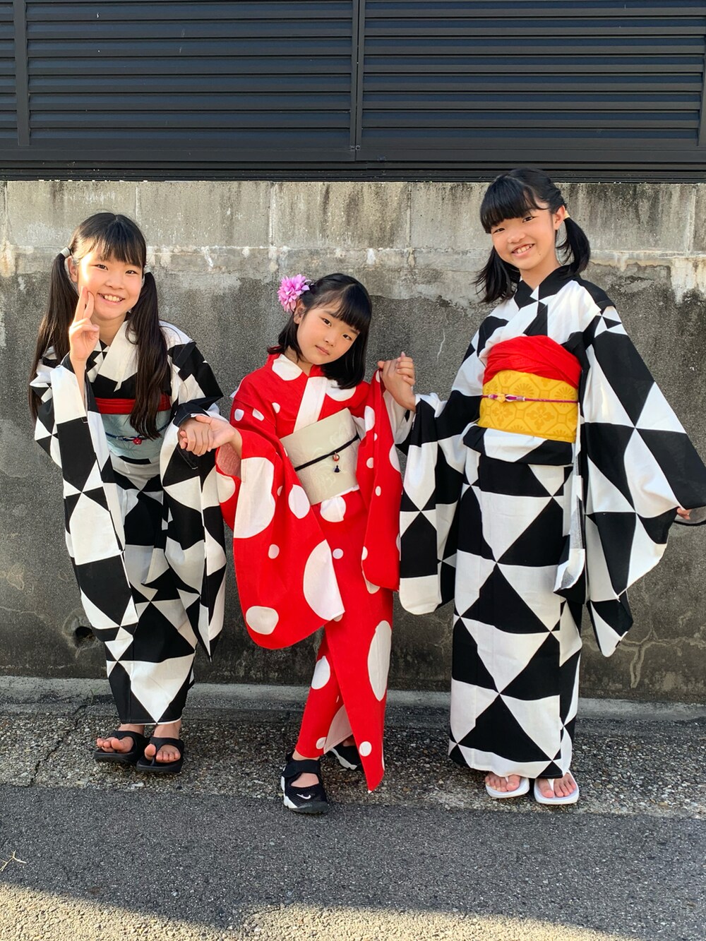 ブラック系のスニーカー、ブラック系の浴衣、レッド系の浴衣を着用したキッズの夏コーディネートの2枚目の写真