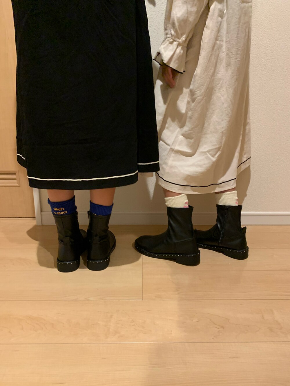 ブラック系のワンピース、ホワイト系のワンピース、ブラック系のブーツを着用したキッズの秋コーディネートの2枚目の写真