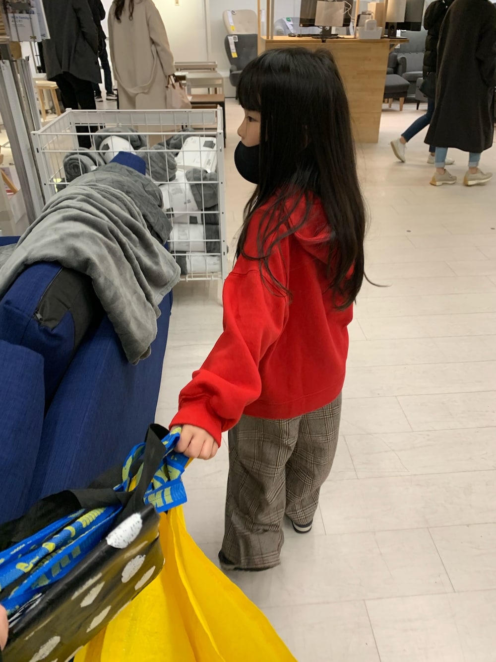 レッド系のパーカー、ベージュ系のパーカー、ブラウン系のパンツを着用したキッズの冬コーディネートの2枚目の写真