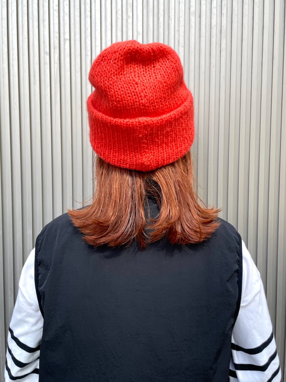 オレンジ系のニットキャップ/ビーニーを着用したレディースの秋コーディネートの6枚目の写真