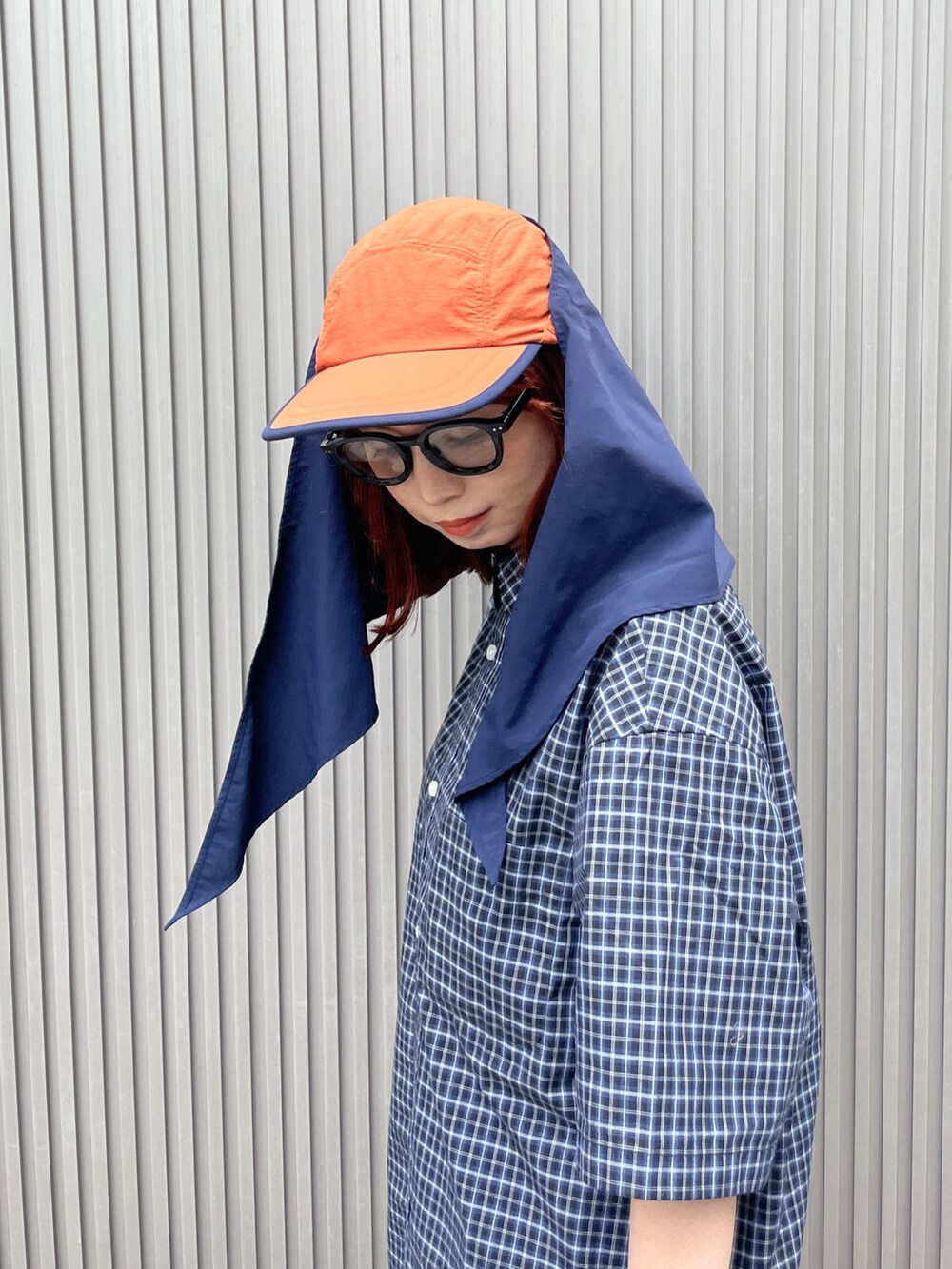 オレンジ系のキャップを着用したレディースの夏コーディネートの5枚目の写真