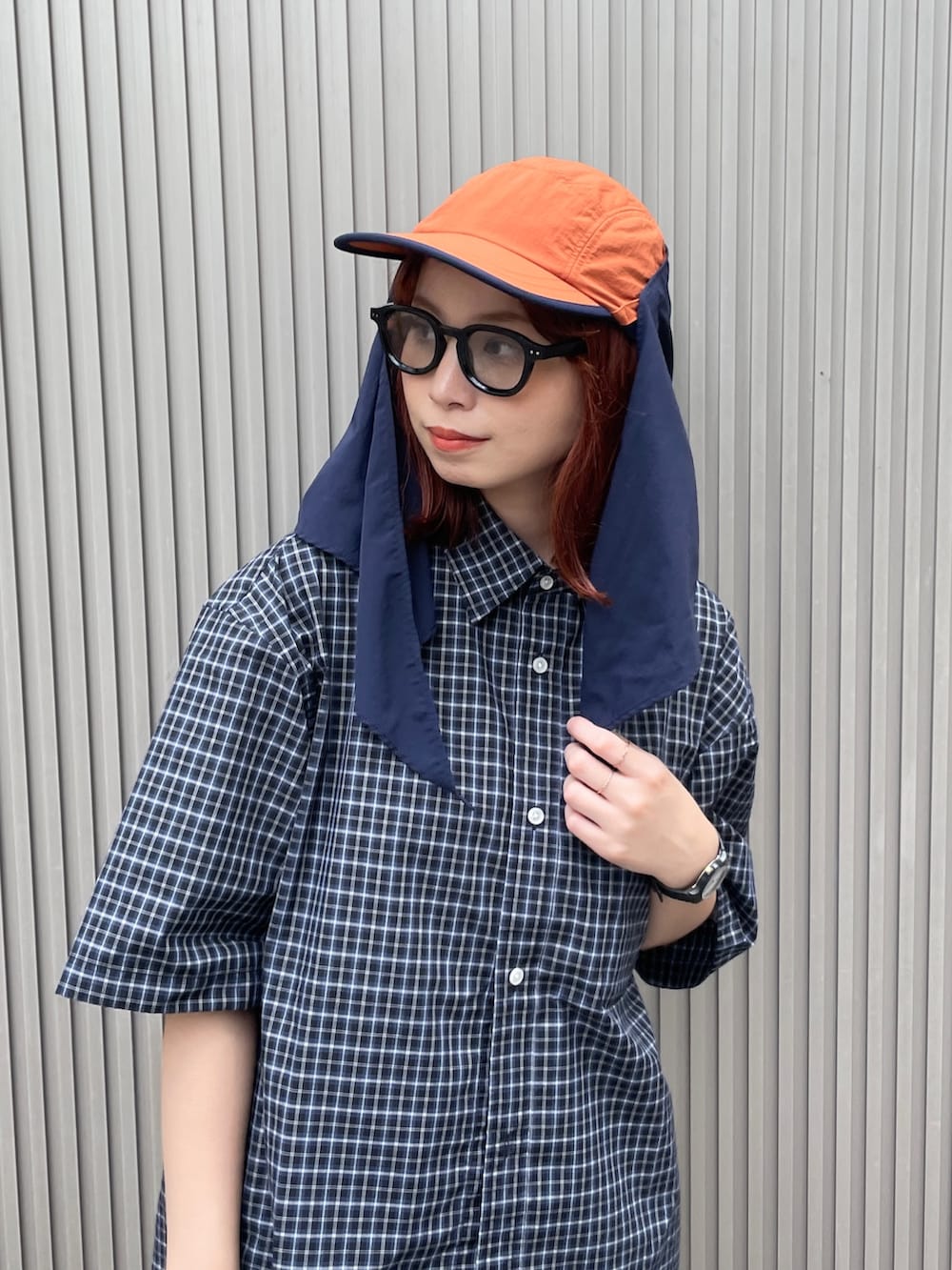 オレンジ系のキャップを着用したレディースの夏コーディネートの3枚目の写真