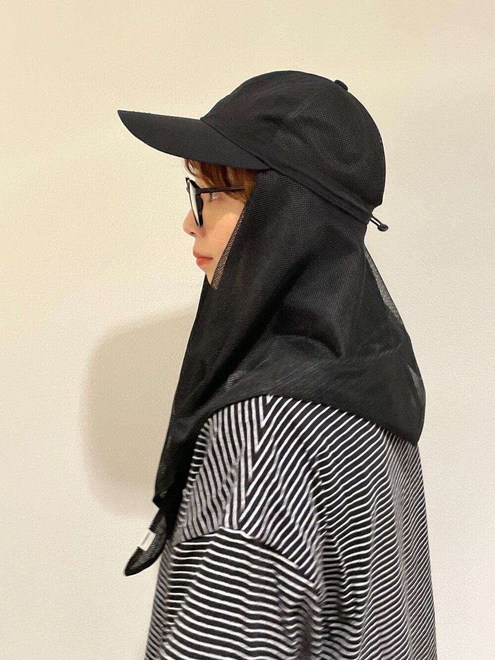 ブラック系のキャップを着用したレディースの春コーディネートの5枚目の写真