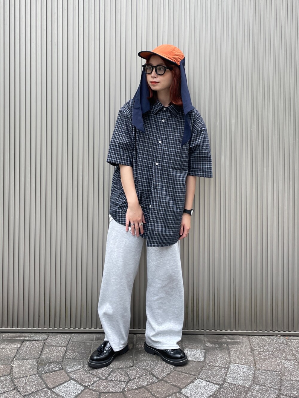 オレンジ系のキャップを着用したレディースの夏コーディネートの2枚目の写真