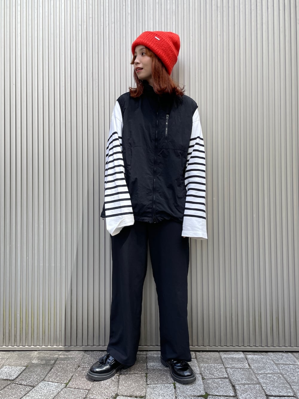 オレンジ系のニットキャップ/ビーニーを着用したレディースの秋コーディネートの2枚目の写真