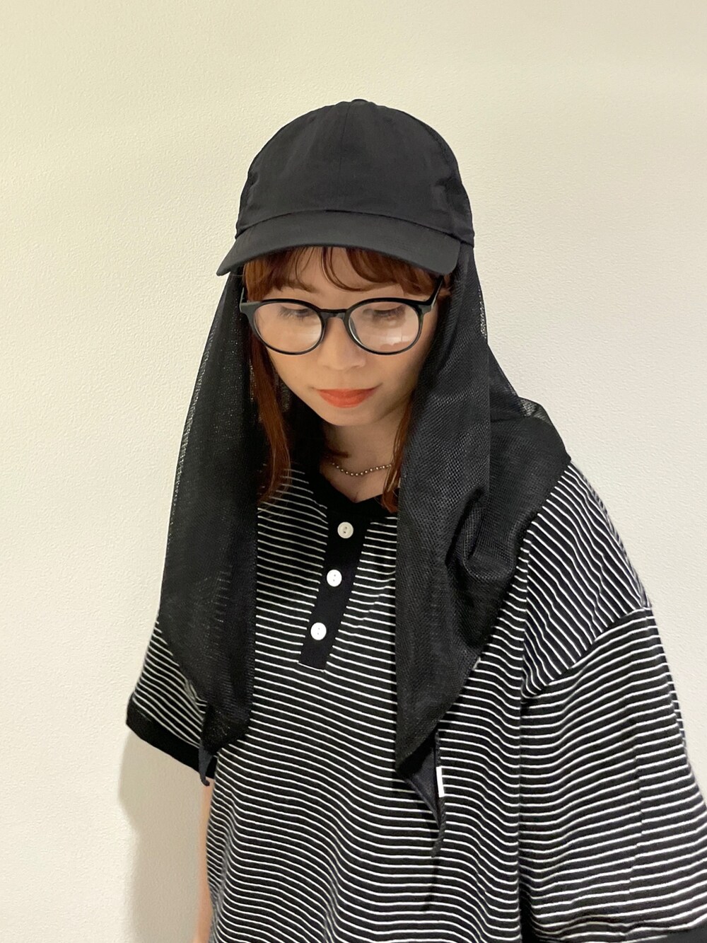 ブラック系のキャップを着用したレディースの春コーディネートの3枚目の写真