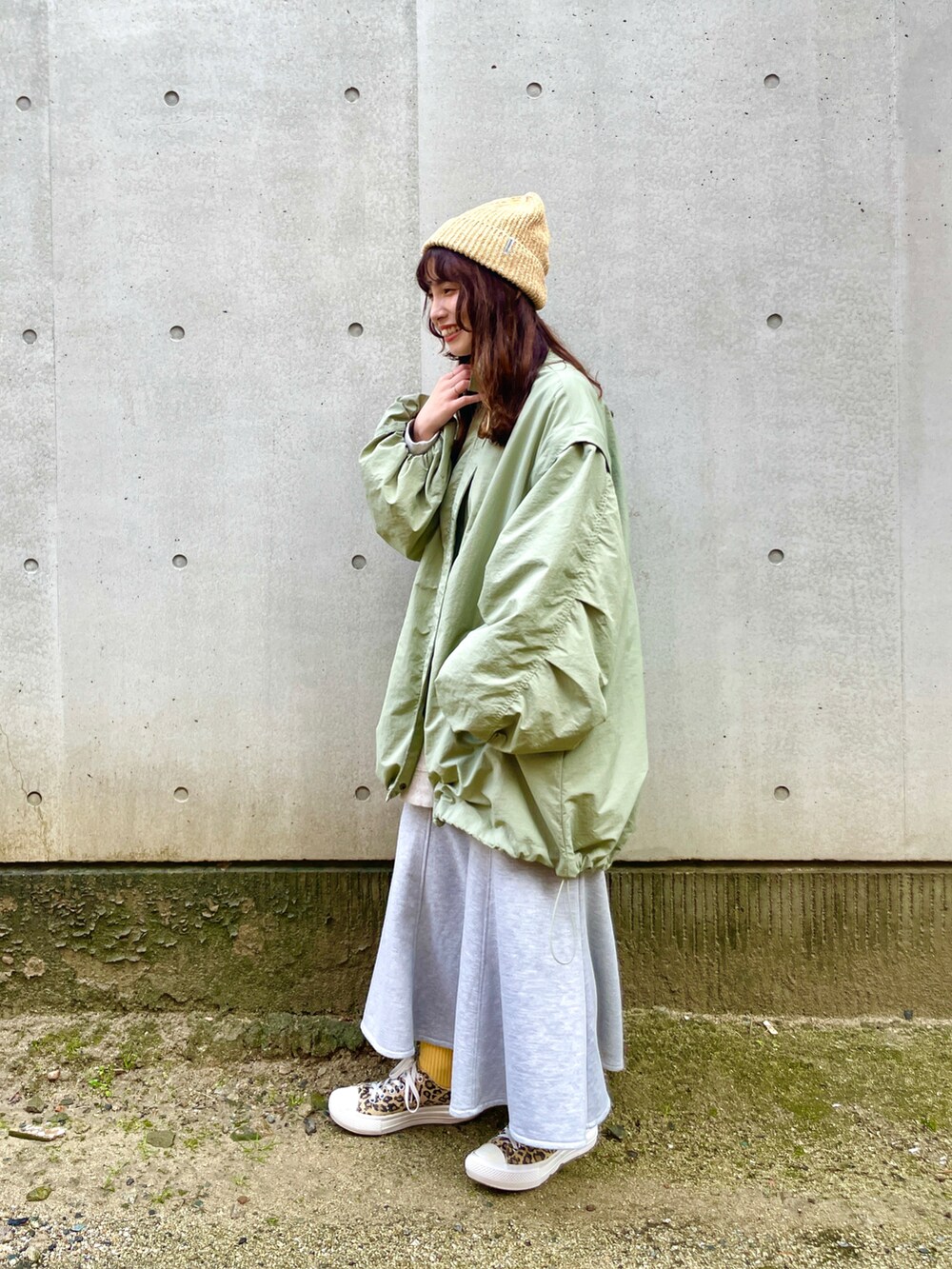 イエロー系のニットキャップ/ビーニーを着用したレディースの冬コーディネートの2枚目の写真