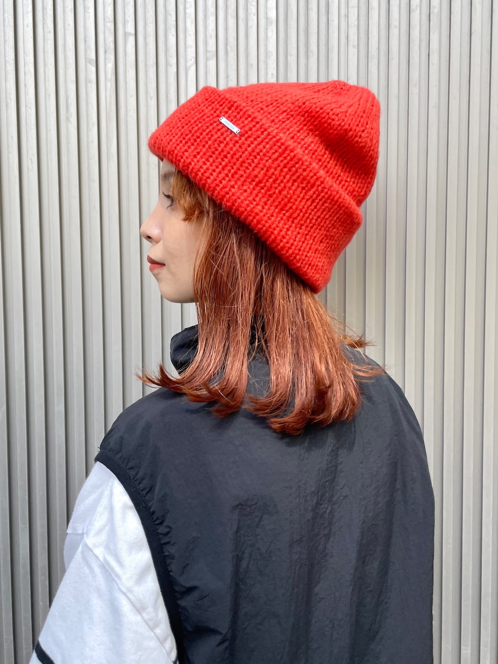 オレンジ系のニットキャップ/ビーニーを着用したレディースの秋コーディネートの5枚目の写真
