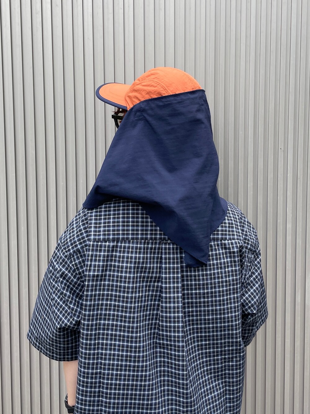 オレンジ系のキャップを着用したレディースの夏コーディネートの6枚目の写真